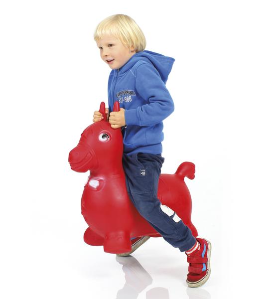 Kind auf rotem Hüpfpferd-Spielzeug, trägt blaue Kapuzenjacke und Turnschuhe.