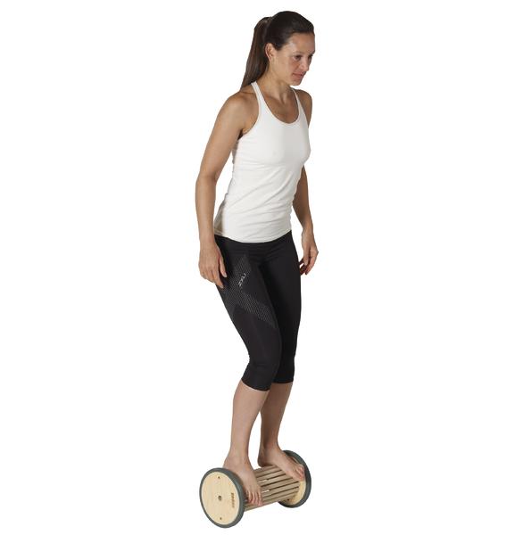 Frau balanciert auf einem Holz-Balance-Board für Gleichgewichtstraining.