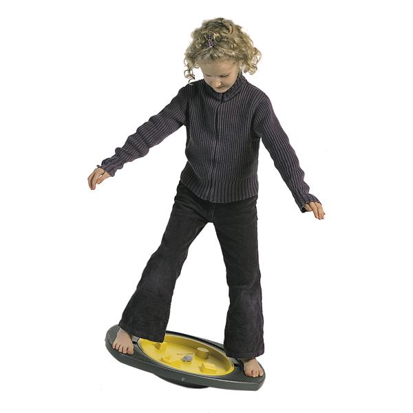 Kind balanciert auf einem gelben Balance-Board, trägt schwarzen Pullover und Hose.