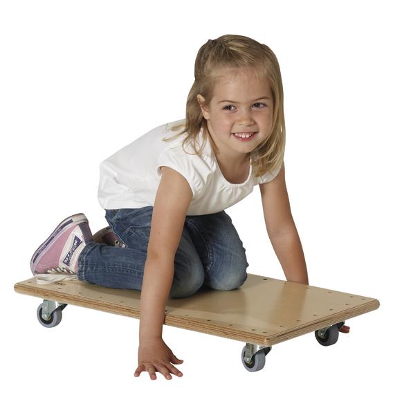 Kind auf Rollbrett in weißem T-Shirt und Jeans, spielend und lächelnd vor weißem Hintergrund.