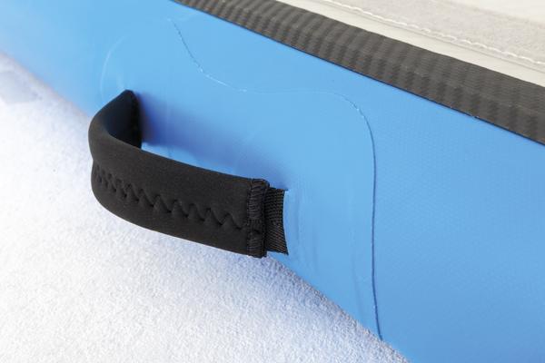 Blauer Griff aus Neopren an aufblasbarer Sportmatte auf weißem Untergrund.