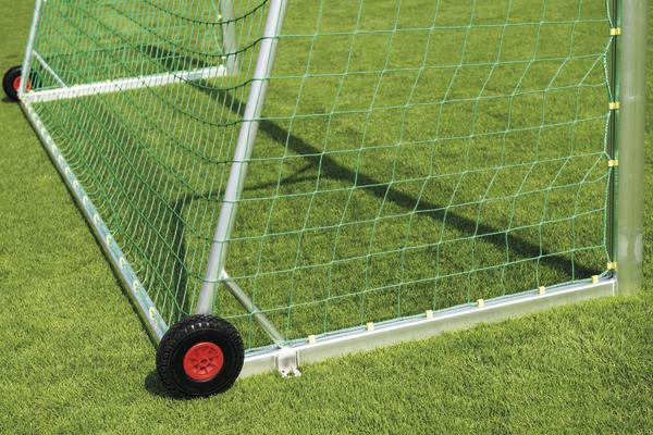 Mobiles Fußballtor mit grünem Netz und Rädern auf gepflegtem Rasenplatz.