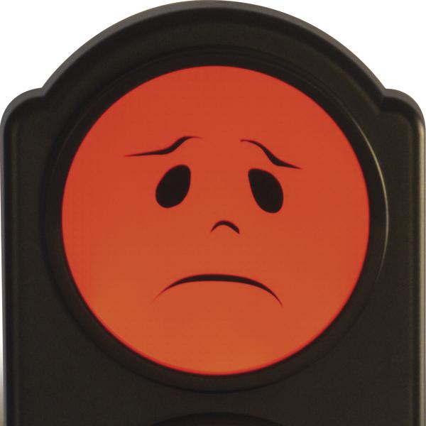 Rotes Warnsignal von einer Ampel mit traurigem Gesichtssymbol auf schwarzem Hintergrund.