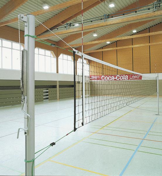 Volleyballnetz in moderner Sporthalle mit Holzbalken und Coca-Cola-Werbung im Hintergrund.