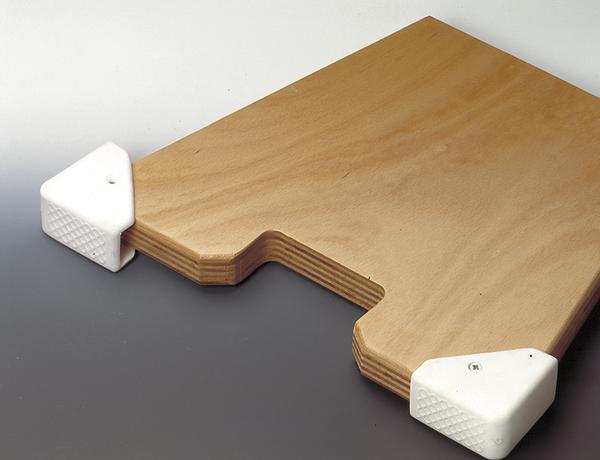 Eckenschutz aus Kunststoff an einer Holzplatte zum Schutz vor Verletzungen und Beschädigungen.