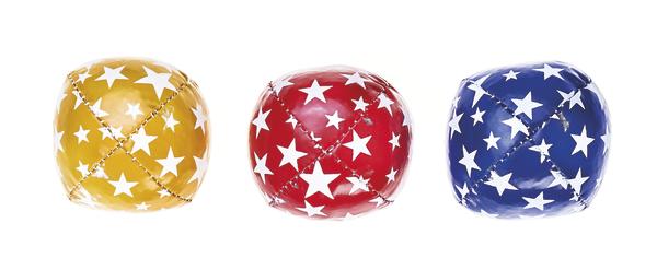 Drei glänzende Jonglierbälle in Gelb, Rot und Blau mit weißen Sternmustern auf weißem Hintergrund.