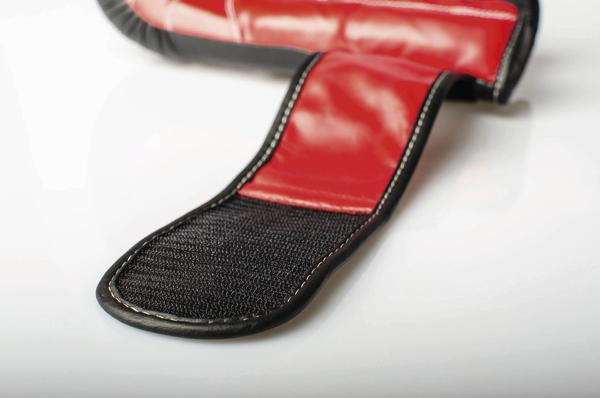 Rotes Boxhandschuh mit Klettverschluss auf weißem Hintergrund, Nahaufnahme.