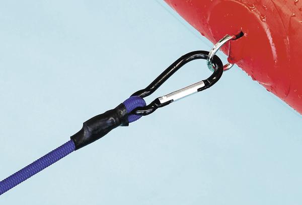 Schwarzer Karabinerhaken verbindet blaues Seil mit rotem Metallring vor blauem Hintergrund.