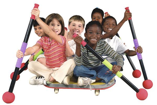 Sechs fröhliche Kinder sitzen auf einem Skateboard und halten bunte Pogo-Sticks.