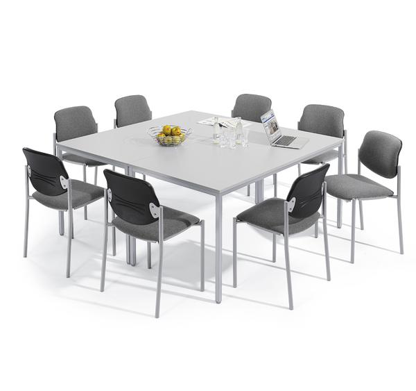 Moderner quadratischer Mehrzewecktisch mit acht grauen Stühlen, Laptop und Obstkorb.