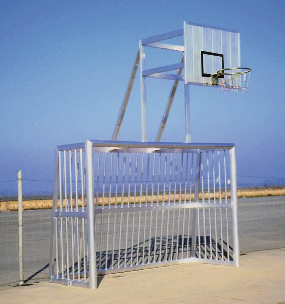 Kombination aus Fußballtor und Basketballkorb auf einem Außenplatz bei klarem Himmel.
