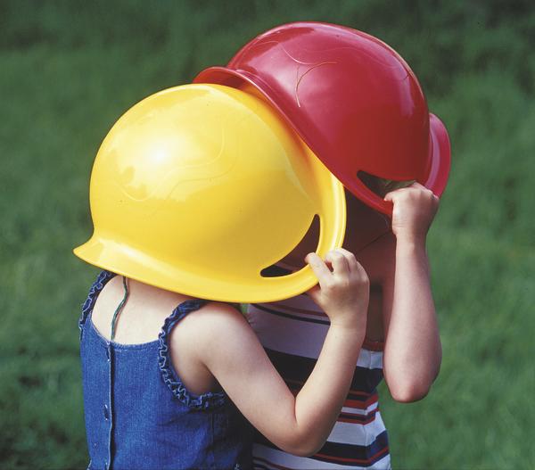 Kinder spielen gemeinsam mit einem großen roten Tuch im Kreis, lachend und fröhlich.