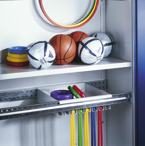 Sportgeräte im Schrank: Bälle, Reifen und bunte Trainingsbänder ordentlich verstaut.