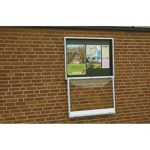 Infotafel mit Stadtplan und Tourismusinformationen an roter Backsteinwand.