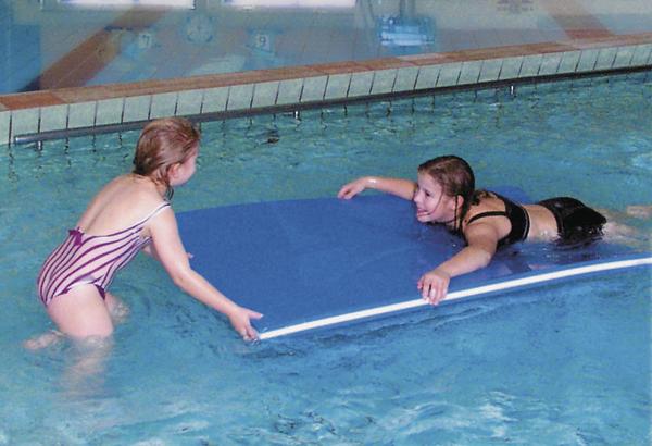 Kinder spielen mit Schwimmbrett im Hallenbad, Schwimmunterricht für Anfänger.