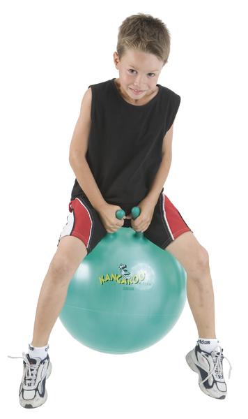 Junge in Sportkleidung springt auf grünem Hüpfball mit Griffen vor weißem Hintergrund.