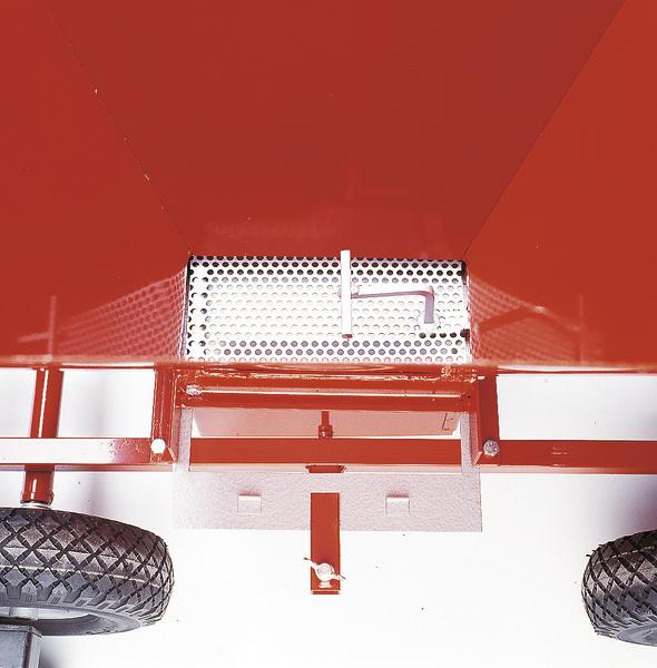 Roter Anhänger mit Metallgitter und zwei Reifen, Nahaufnahme von unten.