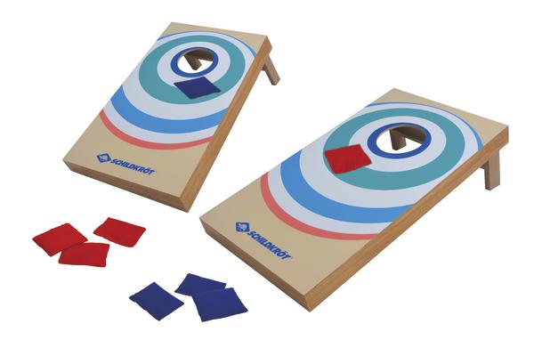 Zwei Cornhole-Bretter mit roten und blauen Wurfsäckchen für das Wurfspiel im Freien.