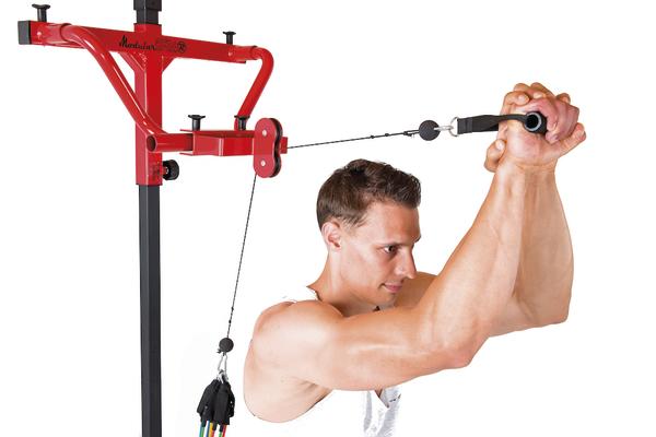 Mann trainiert Schultern mit rotem Kabelzuggerät vor weißem Hintergrund.