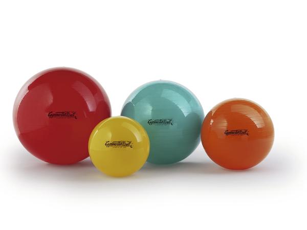 Vier bunte Gymnastikbälle in verschiedenen Größen auf weißem Hintergrund.