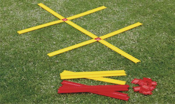Gelbe und rote Markierungsstäbe auf grünem Rasen für Sport- oder Trainingsübungen.