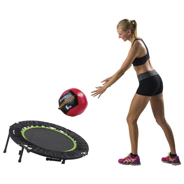 Frau trainiert mit Medizinball und Mini-Trampolin für Kraft und Koordination.
