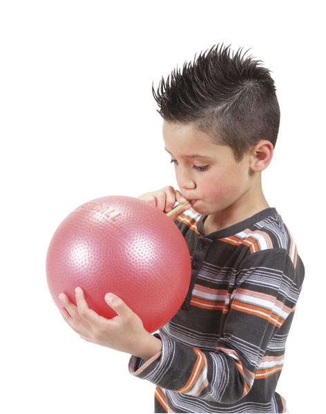 Junge pustet roten Ballon auf, trägt gestreiftes Langarmshirt, weißer Hintergrund.