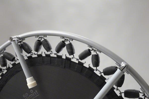Nahaufnahme eines Mini-Trampolins mit Metallrahmen und Federn vor grauem Hintergrund.