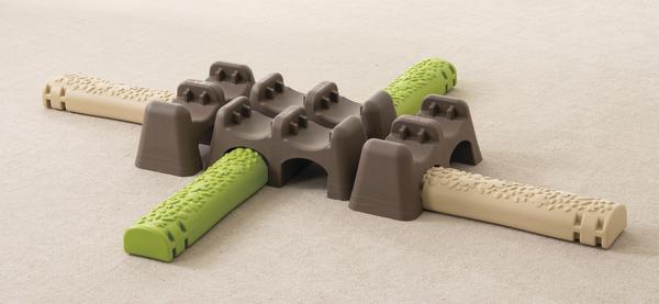 Balancepfad Jungle Trail aus Kunststoff bestehend aus verschiedenen Elementen in brau, grün und beige.