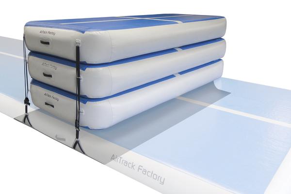 Aufblasbare Airtrack Matte in Blau und Weiß, gestapelt und gesichert mit Gurten.
