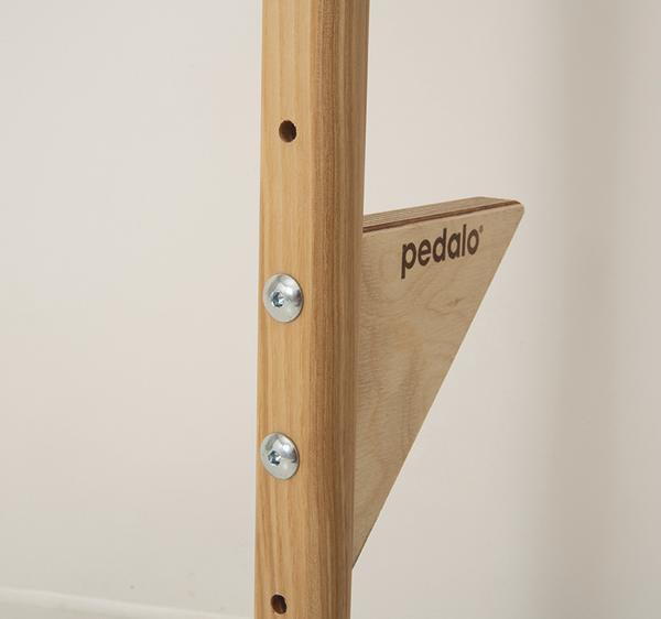 Detailaufnahme eines Holzgerüsts mit "pedalo" Schriftzug und Metallverschraubungen.