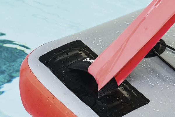 Aufblasbares Stand-Up-Paddle-Board mit festem Finnenhalter im Wasser, Nahaufnahme.