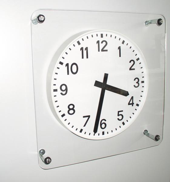 Moderne Wanduhr mit schwarzem Zifferblatt und Zeigern zeigt 16:33 Uhr.