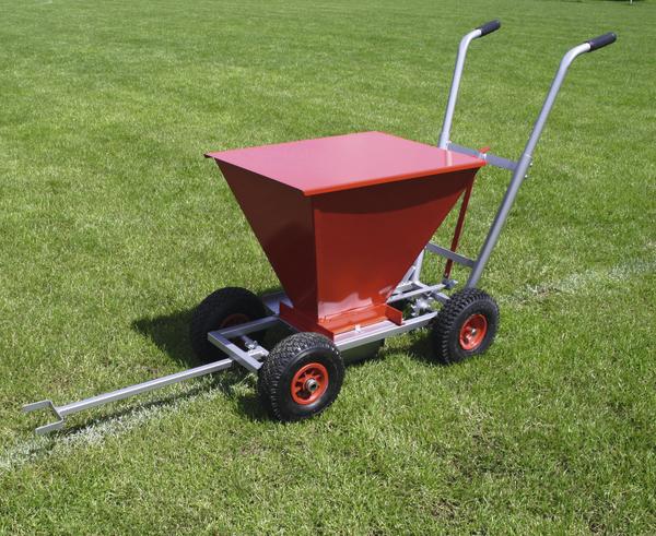 Roter Linienziehwagen mit vier Rädern auf grünem Sportplatz für Spielfeldmarkierung.
