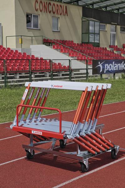 Rote und silberne Hürden auf einem Wagen auf einer Laufbahn vor Tribünen im Stadion Concordia.