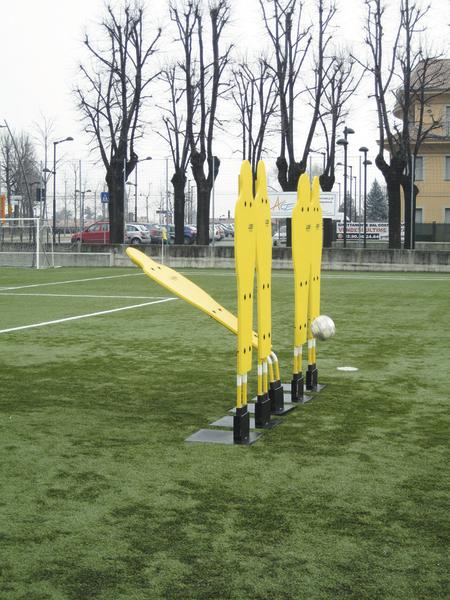 Gelbe Fußball-Trainingspuppen auf grünem Kunstrasenfeld mit Ball.