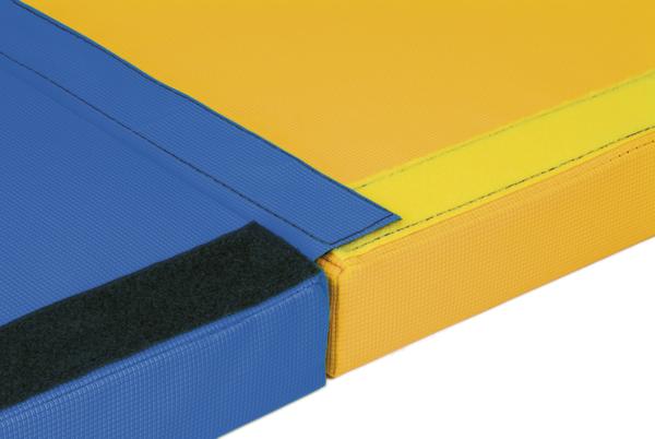 Gelbe und blaue Turnmatten mit Klettverschluss verbunden, Nahaufnahme der Naht und Oberfläche.