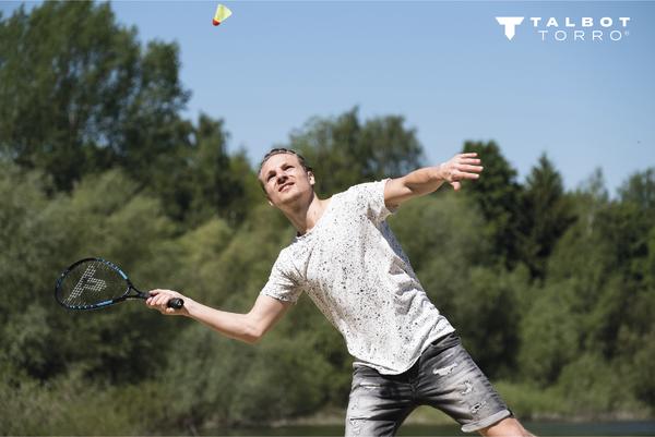 Mann spielt Speedbadminton im Freien und schlägt einen Shuttleball.