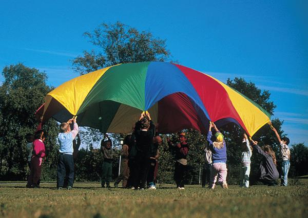 Kinder spielen mit buntem Fallschirm im Freien an sonnigem Tag