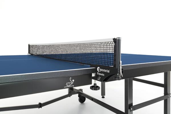 Tischtennisplatte mit blauem Spielfeld und schwarzem Netzgestell, Nahaufnahme.