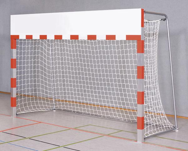 Handballtor mit weißem Netz und rot-weißen Markierungen in einer Sporthalle.