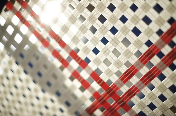 Nahaufnahme eines gewebten Stoffmusters mit roten, weißen und blauen Fäden.