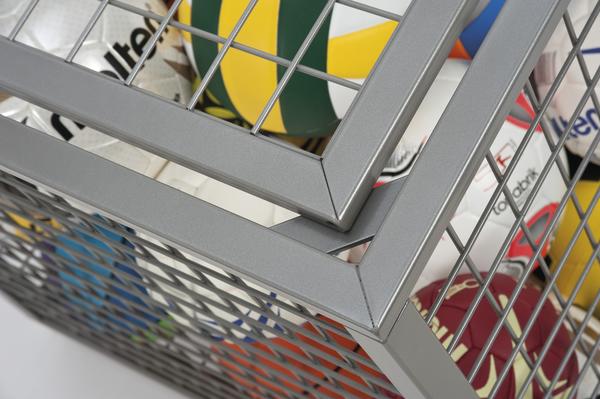 Metallgitterkorb mit verschiedenen Sportbällen wie Volleyball, Basketball und Fußball.