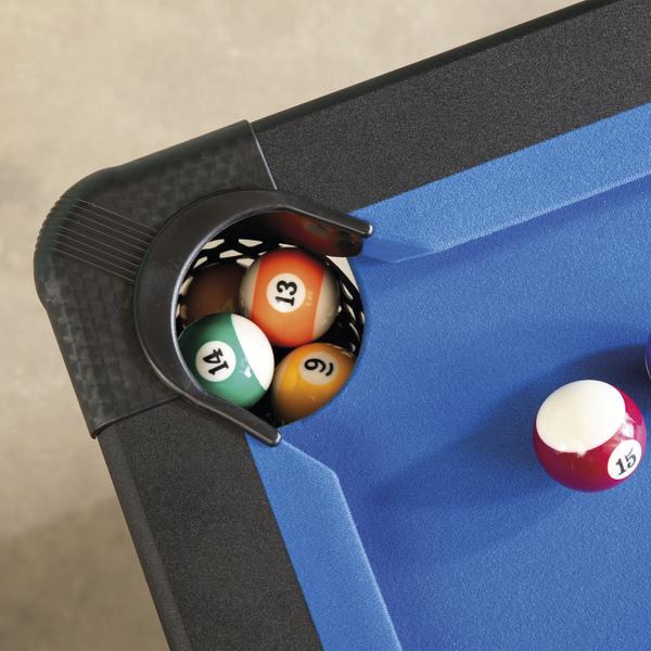 Detailaufnahme einer Billardtisch-Ecktasche mit mehreren Billardkugeln auf blauem Spielfeld.