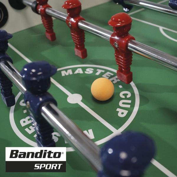 Oranger Bandito Bomber Kickerball auf dem Tischkicker zwischen roten und blauen Spielfiguren