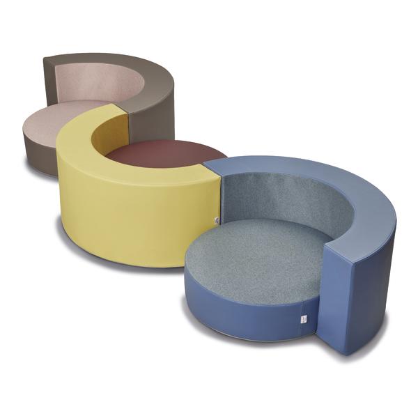 Drei runde Hüpfkissen mit Rückenlehne in verschiedenen Farbvarianten: Taupe, Gelb und Blau.