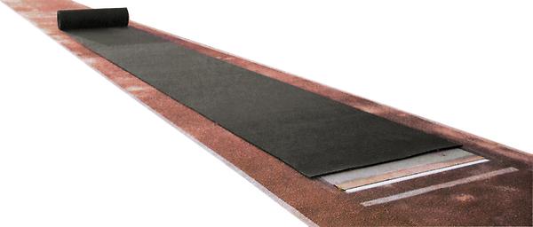 Schwarze Yogamatte auf rotem Boden ausgerollt, Fitness- und Trainingszubehör.