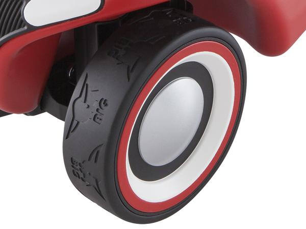 Rotes Spielzeugauto mit schwarzem Reifen und weiß-rotem Felgenring, Nahaufnahme.