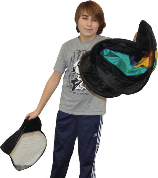 Junge hält zwei bunte Zauberhüte, einer innen mit Regenbogenfarben, vor weißem Hintergrund.