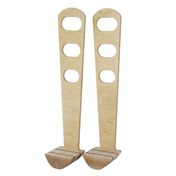 Paar aus Holz gefertigte Stelzen mit Grifföffnungen und gebogenem Fußteil.